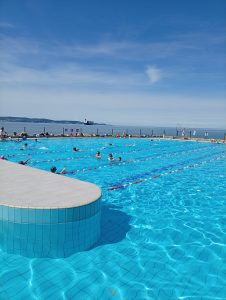 Učenci z voditeljico na ploščadi ob morju in bazenih.